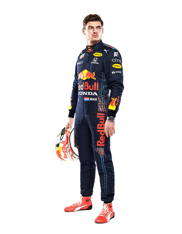 Person wearing a Red Bull racing suit holding a helmet on a white background